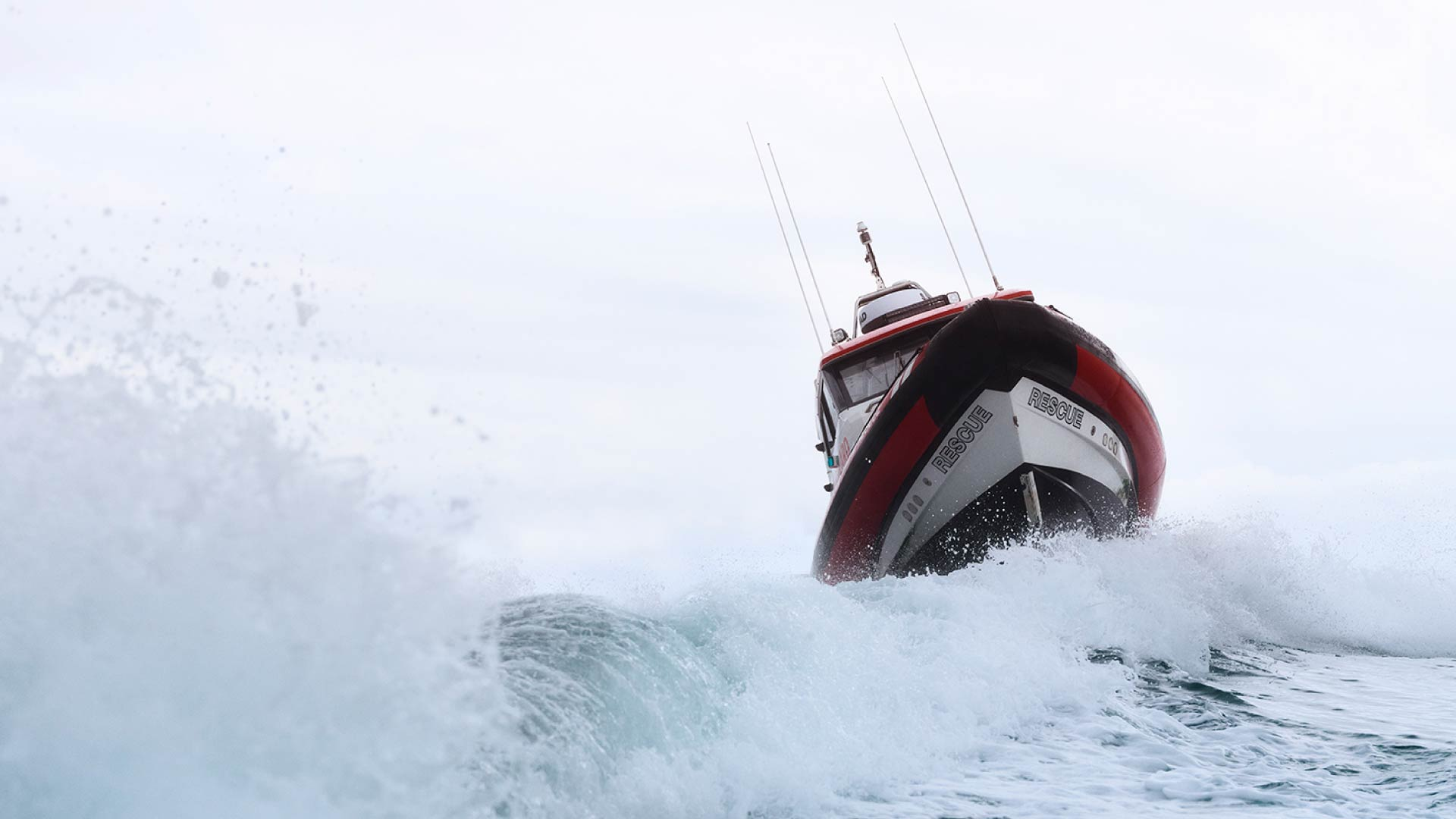 Coastguard rescue boat powering through breaking surf